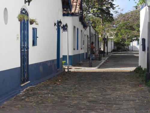 an alley with blue and white buildings and a cobblestone street at Passagem Concept Hotel e Spa in Cabo Frio