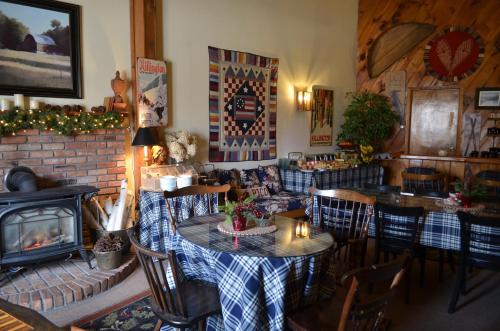 a living room with a table and chairs and a fireplace at Greenbrier Inn Killington in Killington