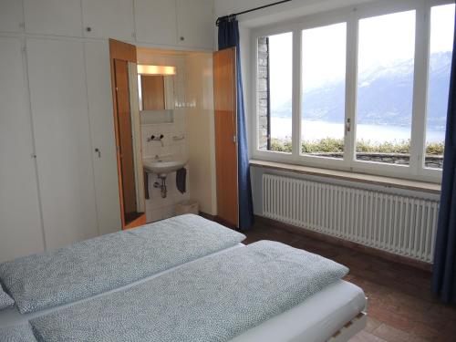 a bedroom with two beds and a sink and a window at La Civetta by Fewotessin in Brissago