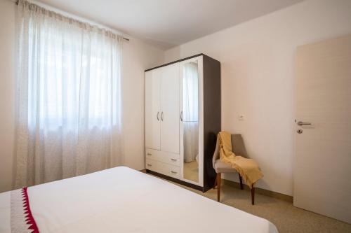 a bedroom with a bed and a mirror and a chair at Holiday Home Petra in Podstrana