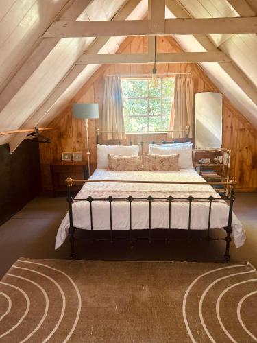 a bedroom with a large bed in a attic at Highlands Farm Cottage in Van Reenen