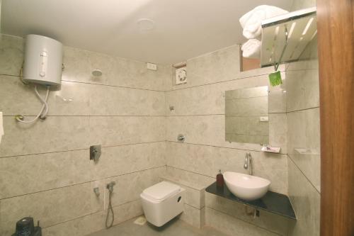 a bathroom with a toilet and a sink at Hotel Rajpath Inn in Mahesāna