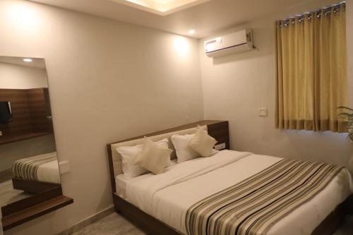 a bedroom with a large bed with a mirror at Hotel Rajpath Inn in Mahesāna