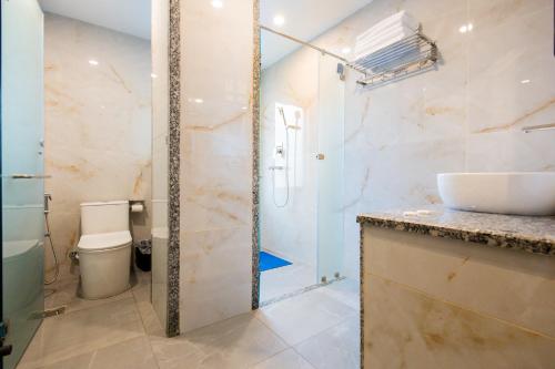 a bathroom with a shower and a sink and a toilet at Tulsi Kathmandu Hotel in Kathmandu