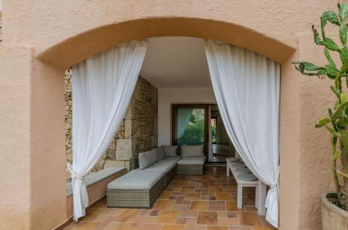 uma sala de estar com um sofá e cortinas em Between sea and rocks em Porto Cervo