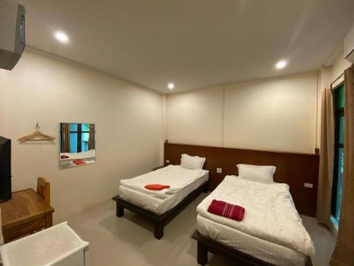 a bedroom with two beds and a sink and a mirror at JITRA RESORT in Sukhothai
