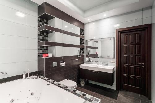 y baño con bañera, aseo y lavamanos. en Minskhouse Apartments 2, en Minsk