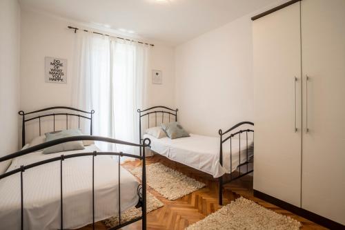 a bedroom with two beds and a closet at Holiday Home Petra in Podstrana