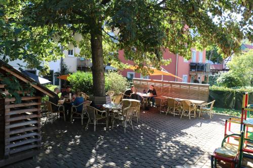 a group of people sitting at tables under a tree at Double B in Erfurt