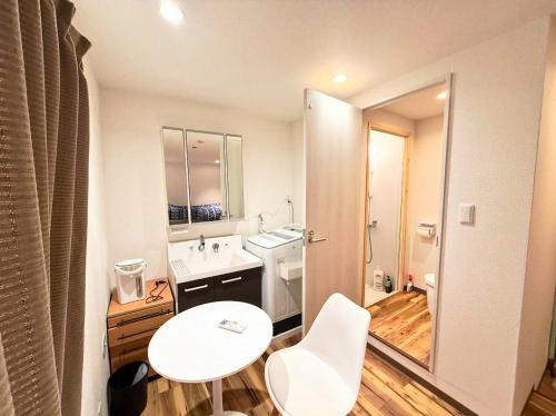 a white bathroom with a sink and a mirror at Sunny Haven in Tokyo in Tokyo