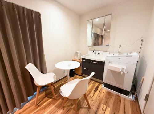 a bathroom with a sink and a table and chairs at Sunny Haven in Tokyo in Tokyo