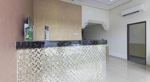 une salle de bain avec un comptoir en carrelage doré dans une pièce dans l'établissement Hotel Sunsurya, à Kampong Batu Belah