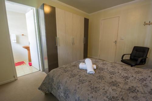 a bedroom with a bed with a white towel on it at Casa Rua Padre Carmene in Gramado