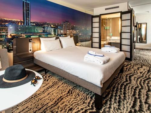a hotel room with a bed and a city skyline at Novotel Paris 14 Porte d'Orléans in Paris