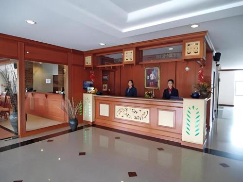 zwei Personen sitzen in einer Bar in einem Gebäude in der Unterkunft Kiengpiman Hotel in Mukdahan