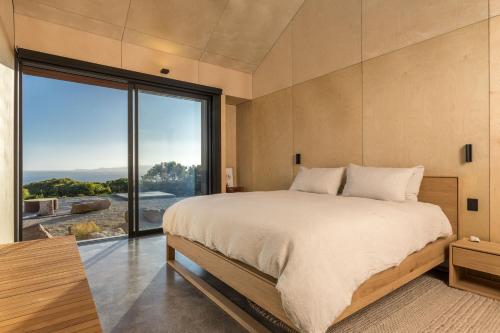 a bedroom with a large bed and a large window at Native Dog Cabin in Bremer Bay