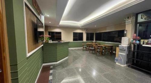 eine Küche mit grünen Wänden und einem Tisch und Stühlen in der Unterkunft Kiatwimon Hotel in Sathani Phitsanulok