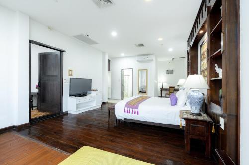 a large bedroom with a bed and a television at Cheva Gallery Boutique Hotel in Chiang Mai