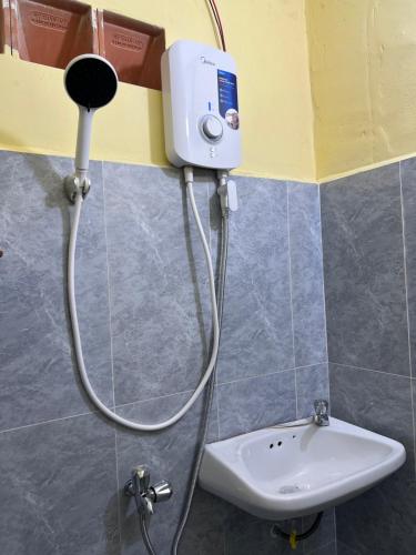 a shower head in a bathroom with a sink at Para Hostel Kohrong in Kaôh Rŭng (3)