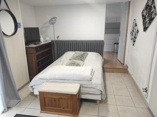 una piccola camera da letto con un letto e una cassettiera di Chambre entrée indépendante a Lodève