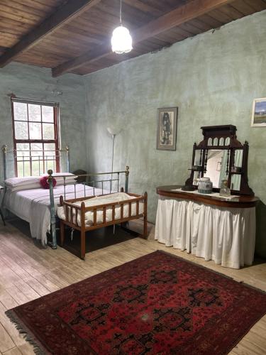 a bedroom with a bed and a table in a room at Ouma se Plaashuis - Martine se kamer in Van Reenen