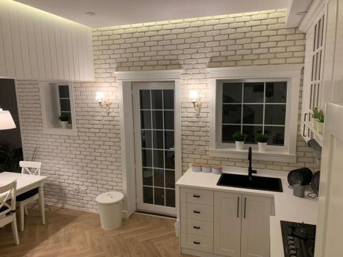 a kitchen with a sink and a brick wall at White House in Madinaty