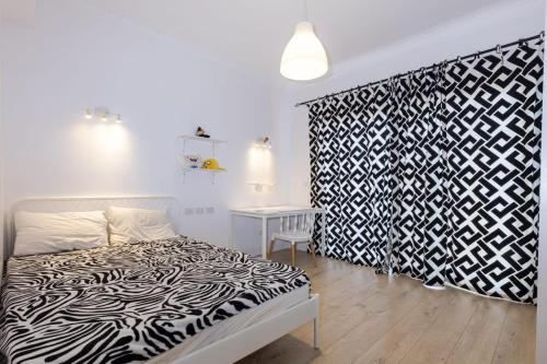 a bedroom with a black and white bed and a table at White House in Madinaty