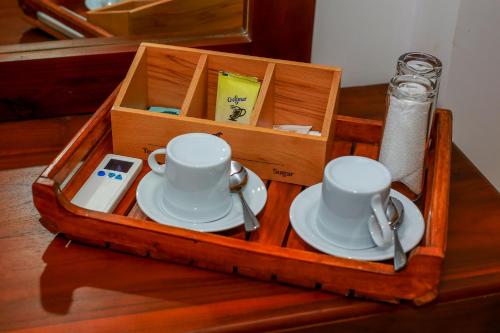 een houten blad met bekers en schotels op een tafel bij Ayana Resort Wilpattu in Anuradhapura