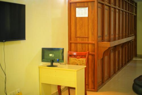 a room with a desk and a tv and a table at KIGALI QUEENs HOME AND APARTMENT in Kigali