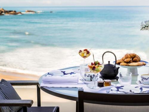 a table with food on the beach with the ocean at Sofitel Biarritz Le Miramar Thalassa in Biarritz