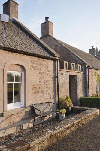 a bench sitting in front of a building at Woodview Cottage in Glamis