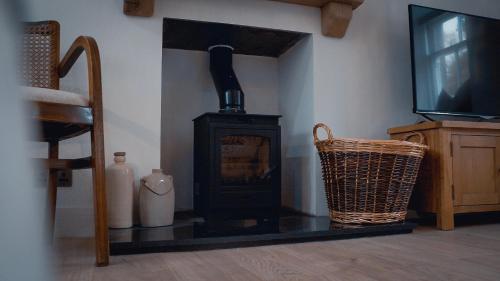 a fireplace in a room with a chair and a television at Woodview Cottage in Glamis