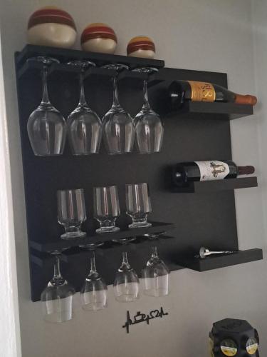 un mucchio di bicchieri da vino e bottiglie di vino su uno scaffale di Hospedagem Altas da Quitéria Suíte 02 a Catas Altas