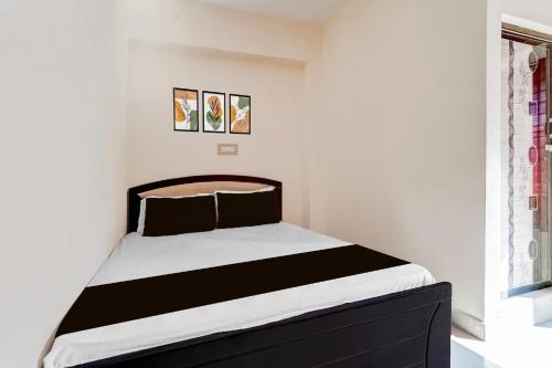 a bedroom with a black and white bed and a window at Hotel O by OYO Hill Top Hotel in Vānivilāsa Puram
