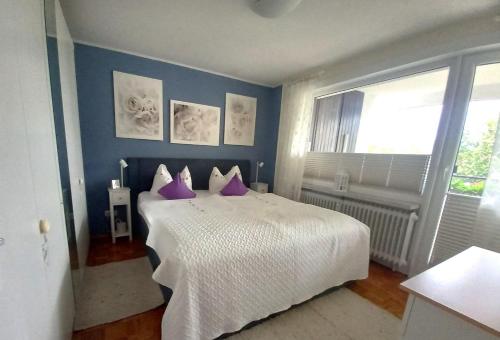 een slaapkamer met een groot wit bed met paarse kussens bij Harz-Fewo-Wolf in Bad Harzburg