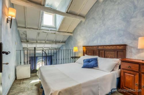 ein Schlafzimmer mit einem Bett mit einem blauen Kissen darauf in der Unterkunft Relais Pian Di Vico in Tuscania
