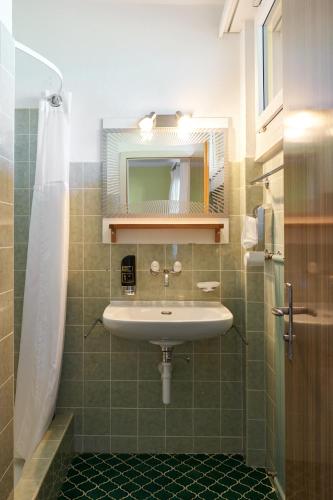 a bathroom with a sink and a mirror at Hotel Bellavista Ftan in Ftan