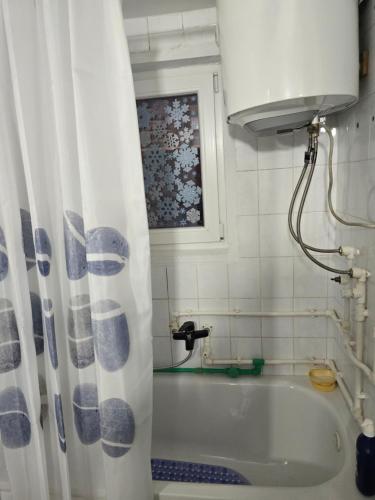 a bath tub with a shower curtain in a bathroom at Premecki konak in Čačak