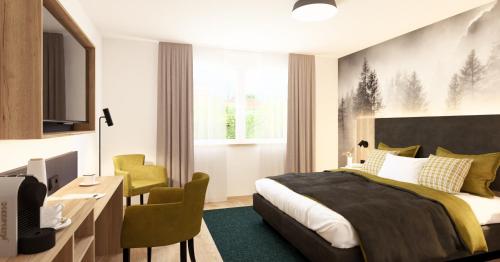 a bedroom with a bed and a desk and a chair at Wohlfühlhotel zur Grässelmühle in Sasbach in der Ortenau
