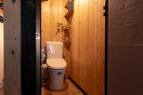 e bagno con servizi igienici su una parete in legno. di Kashiwaya Inn a Nagiso