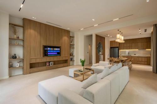 een woonkamer met witte banken en een tv bij Green Villas Tropical Phú Quốc in Phu Quoc