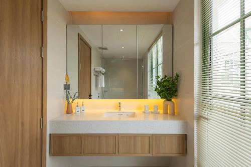 een badkamer met een wastafel en een grote spiegel bij Green Villas Tropical Phú Quốc in Phu Quoc