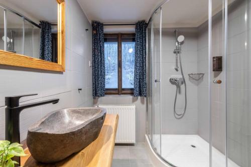 a bathroom with a stone tub and a shower at Štepánka - Chalet & SPA in Benecko