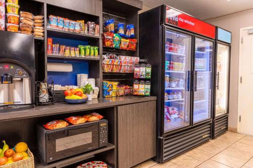 a kitchen with a refrigerator and a microwave at Sonesta Simply Suites Arlington Entertainment District in Arlington