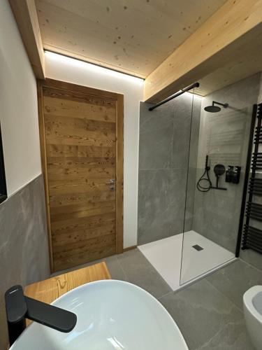 ein Badezimmer mit Badewanne, Dusche und Waschbecken in der Unterkunft Maison ValGià in Champoluc
