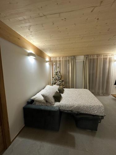 ein Schlafzimmer mit einem Bett mit einem Weihnachtsbaum darauf in der Unterkunft Maison ValGià in Champoluc