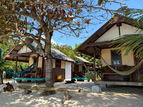 a house with a hammock in front of it at Pinks Bungalow in Baan Tai