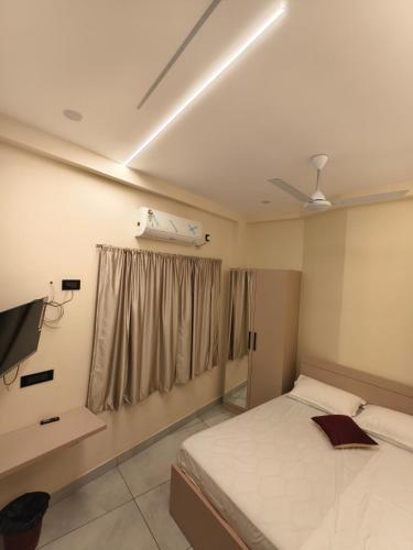 a bedroom with a bed and a ceiling fan at C K Residency in Cochin