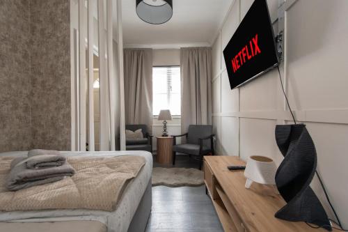 a bedroom with a bed and a tv on the wall at Luxury Studio 1 Bedroom Apartment in Chatham