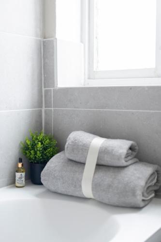 a pile of towels sitting on a counter in a bathroom at Luxury Studio 1 Bedroom Apartment in Chatham